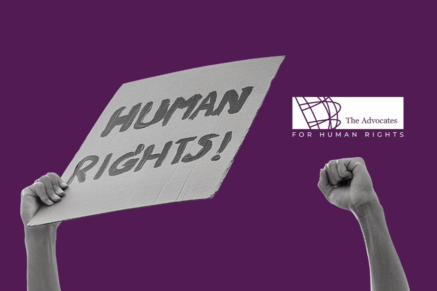 [ai] A hand holding a sign that reads "HUMAN RIGHTS!" in bold letters, with another fist raised beside it. The background is purple, and a logo for "The Advocates for Human Rights" is located on the right side.
